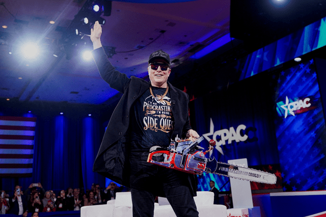 Elon Musk holding a chainsaw onstage as he attends the Conservative Political Action Conference on Feb. 20.