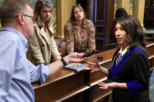 Michigan Rep. Mai Xiong speaking with journalists on the House floor in Lansing, Michigan.