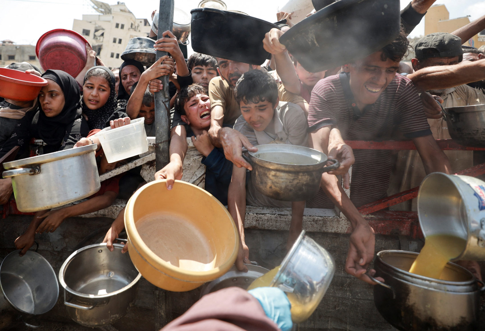 Palestinians wait to receive food from a charity kitchen, in Gaza City