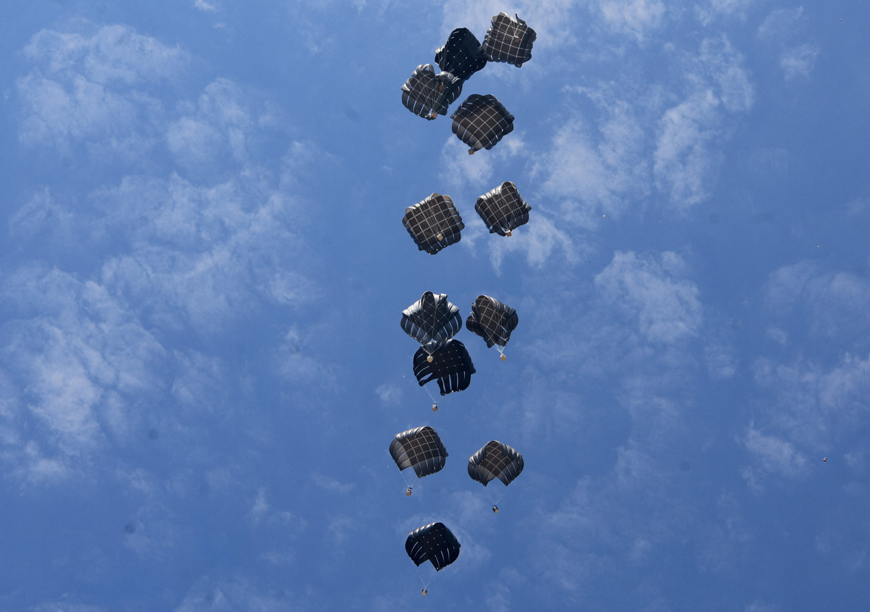 Aid packages dropped from an airplane descend over Gaza, as seen from the central Gaza Strip