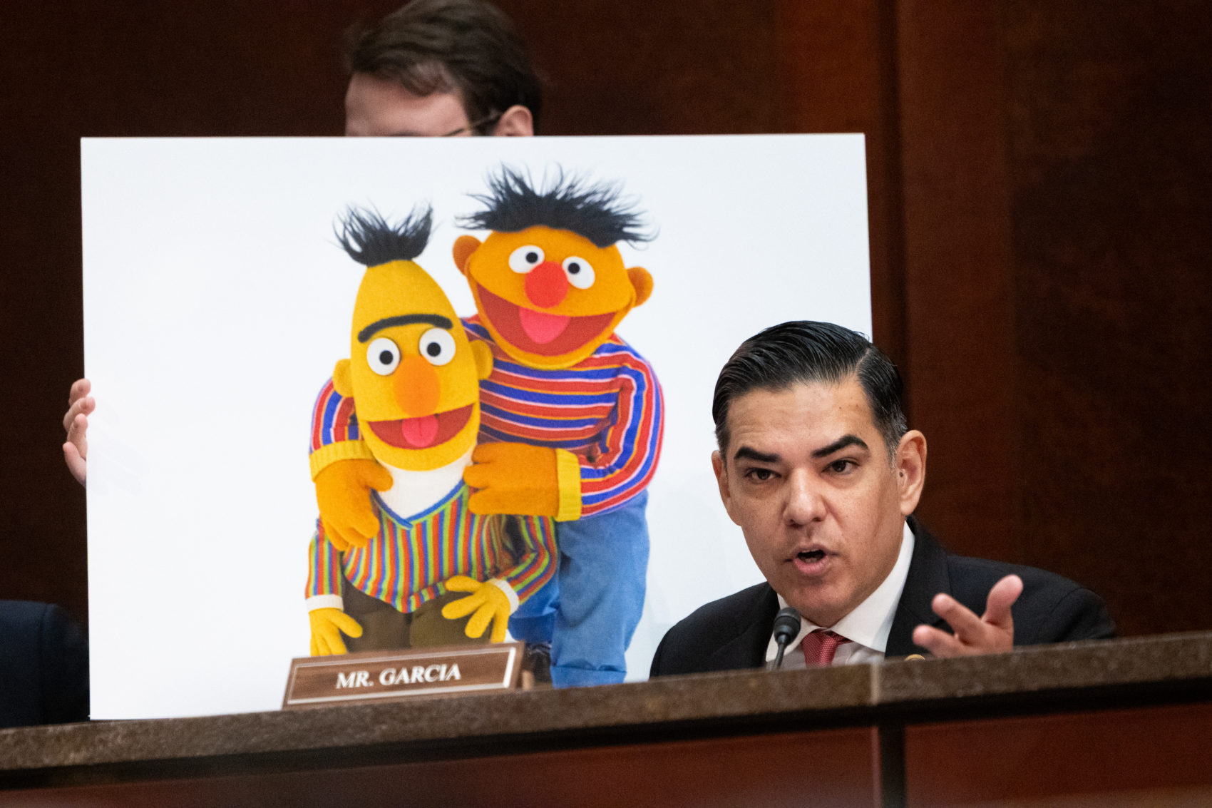 Rep. Robert Garcia, D-Calif., questions witnesses during a House hearing in March. Behind the congressman is an oversized image of Bert and Ernie, beloved Muppet characters in the “Sesame Street,” the children’s TV show that’s long been a staple on PBS.