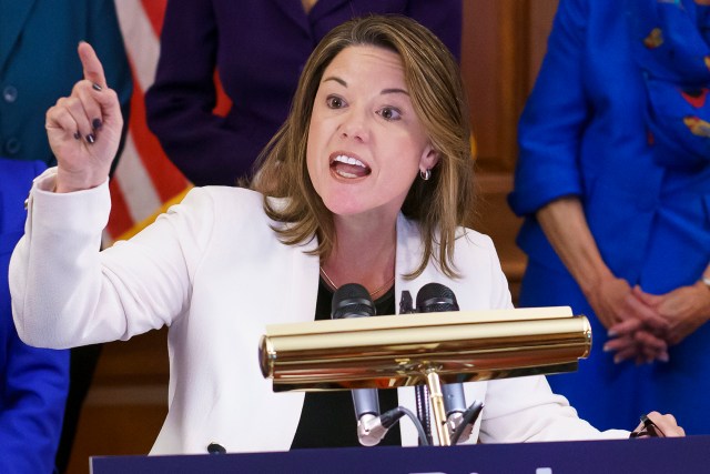 a politician gestures at the lectern
