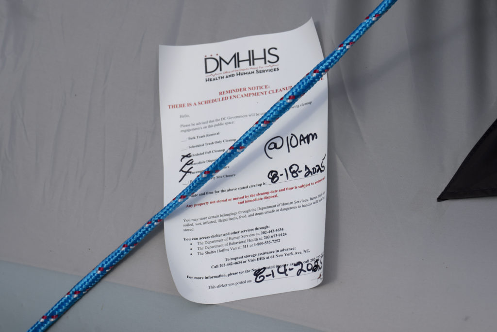 A note is posted on a tent detailing a scheduled encampment cleanup by the Deputy Mayor for Health and Human Services in Washington Circle on August 14, 2025 in Washington, DC.