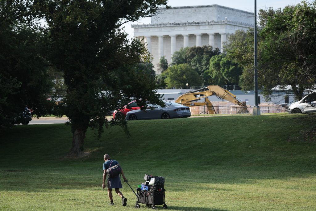 A man clears his belongings from a homeless encampment near the Lincoln Memorial August 14, 2025 in Washington, DC.