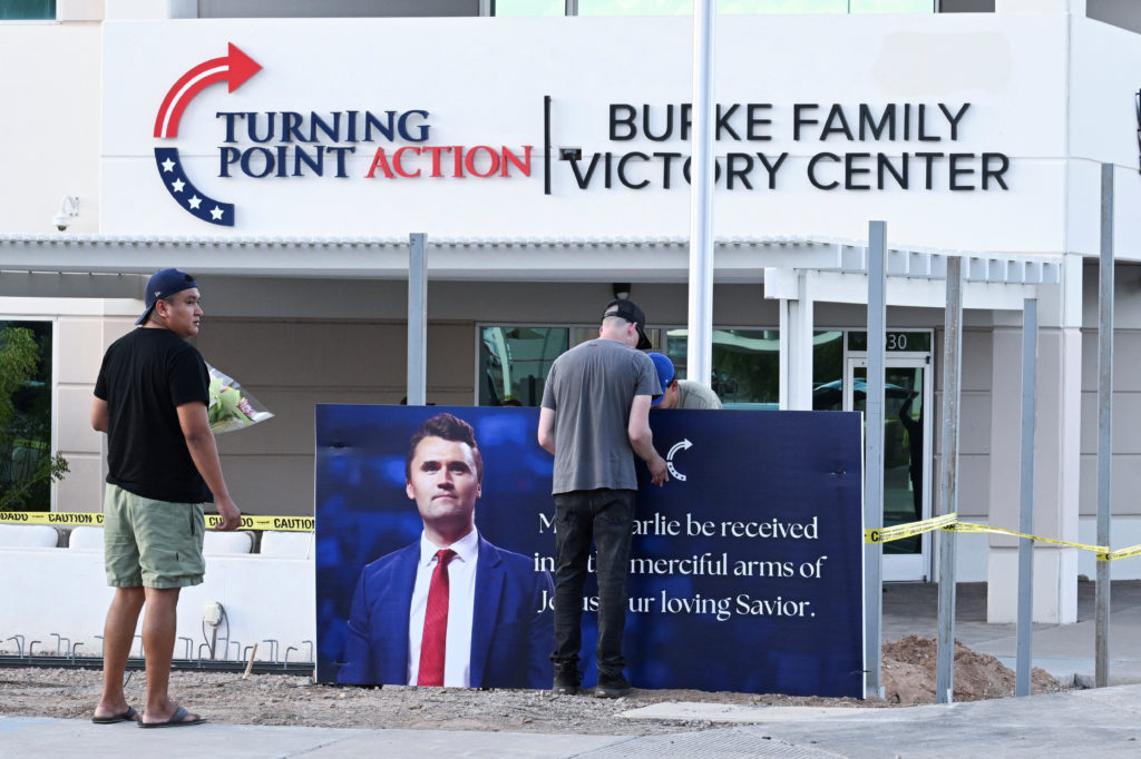 Mourners bring flowers to a memorial for Charlie Kirk, who was shot and killed in Utah, outside Turning Point in Phoenix