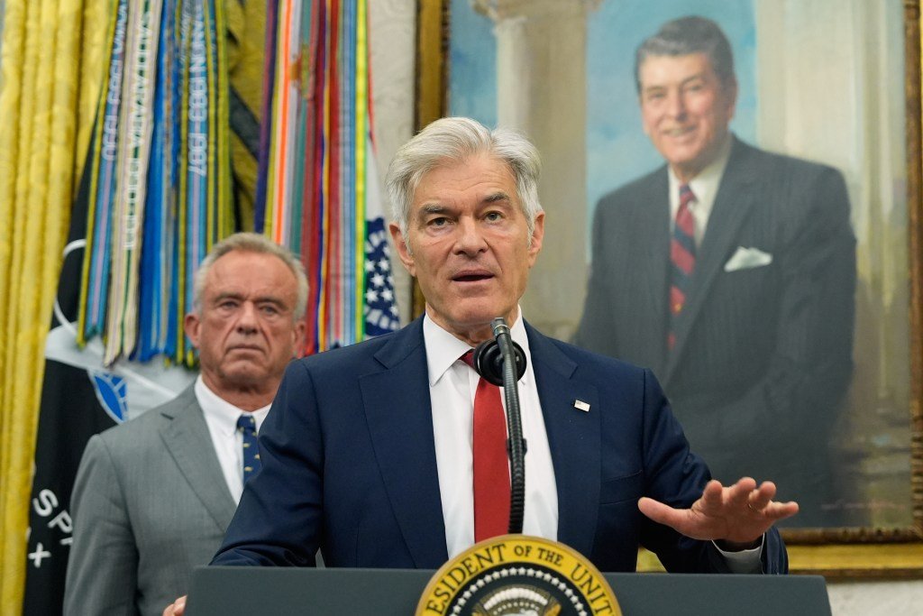 a man in a suit stands in front of a man in a suit and another main in a suit that is in a painting