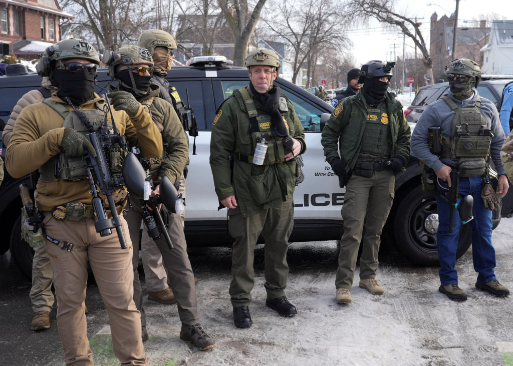 Members of U.S. Immigration and Customs Enforcement (ICE) stand guard after a driver of a vehicle was shot in Minneapolis
