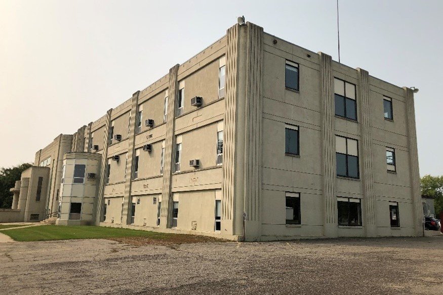 Tan three-story building photographed from the side.