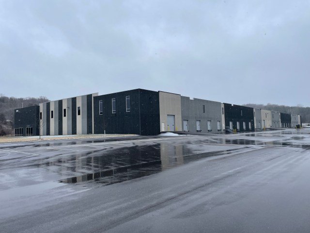 a low-slung modern warehouse with a wet parking lot