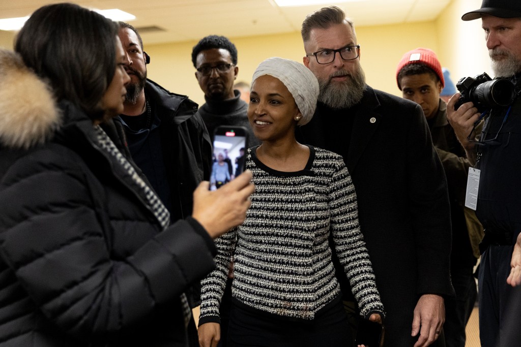 A woman walking surrounded by people on either side.
