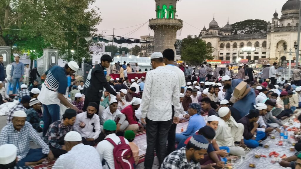 People gathered for the first iftar at Makkah Masjid, with community members sharing a meal to mark the b.