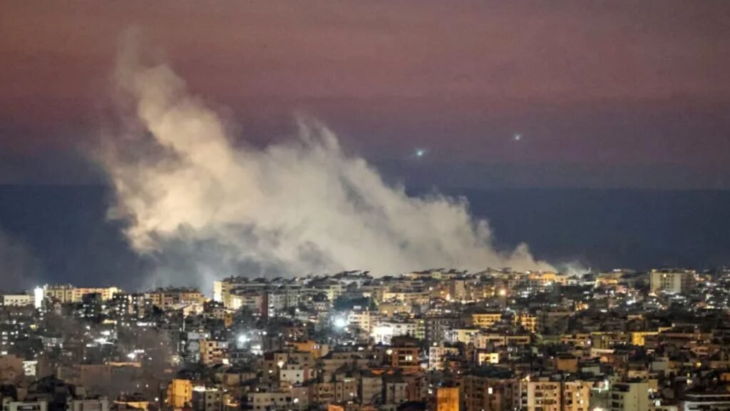 Explosion and smoke over a city skyline during night time, with a dramatic sky in the background.