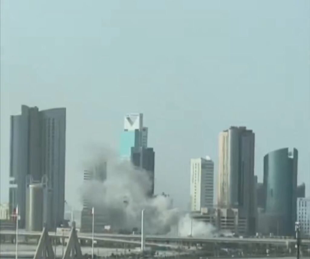 Smoke and dust rise near buildings in Manama after an explosion reportedly linked to an Iranian strike.