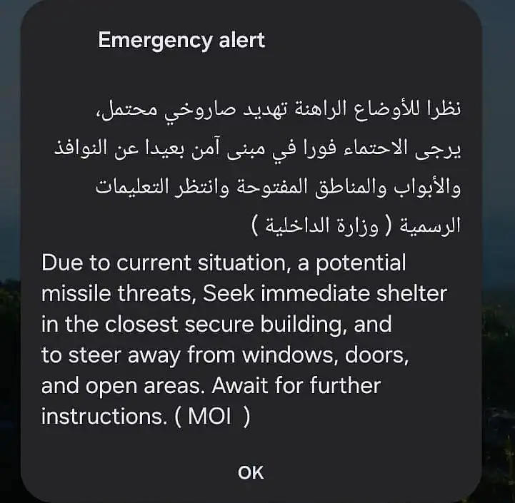 Emergency alert on phone screen warning UAE residents of potential missile threat and urging immediate shelter.